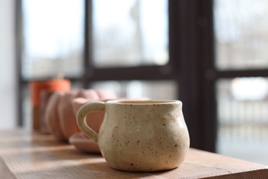 Photo of Beautiful pottery on wooden shelf indoors, closeup