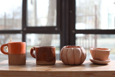 Photo of Beautiful pottery on wooden shelf indoors. Space for text