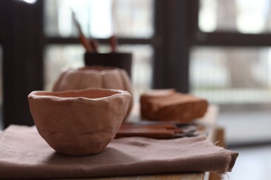 Photo of Handmade ceramic bowl on shelf indoors, closeup