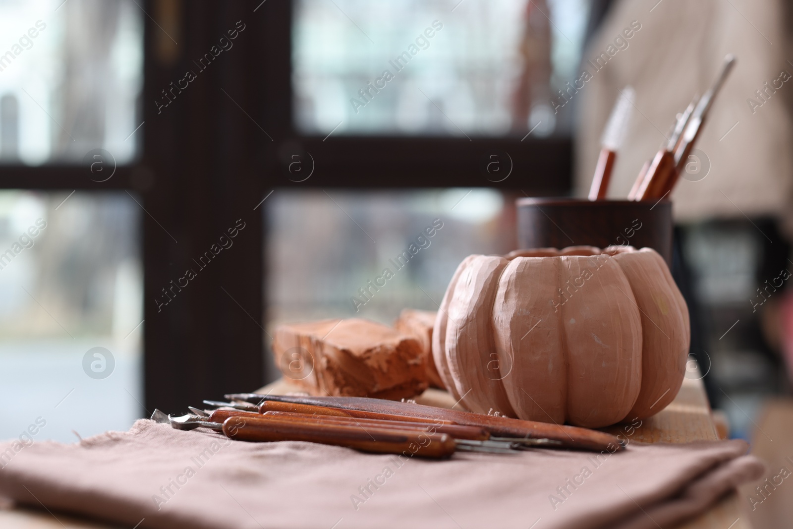 Photo of Set of different crafting tools and pottery on shelf indoors, closeup. Space for text