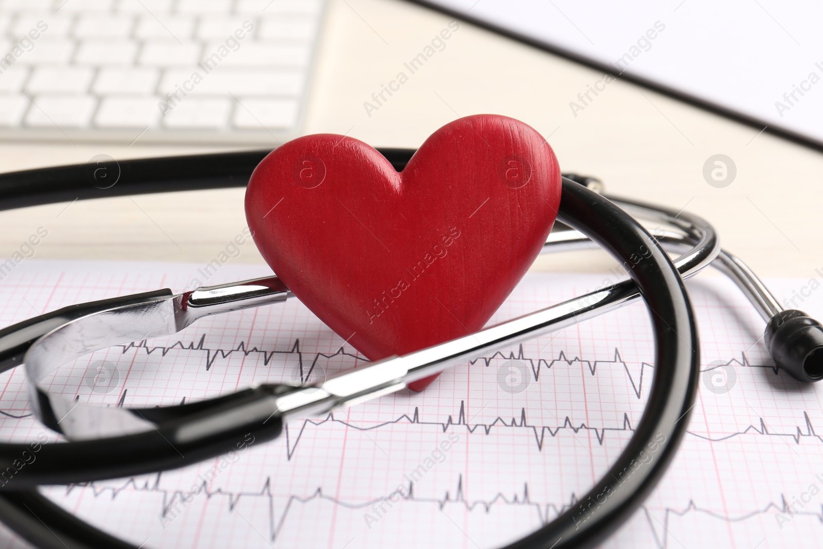 Photo of Cardiology. Stethoscope, cardiogram and red decorative heart on light table, closeup