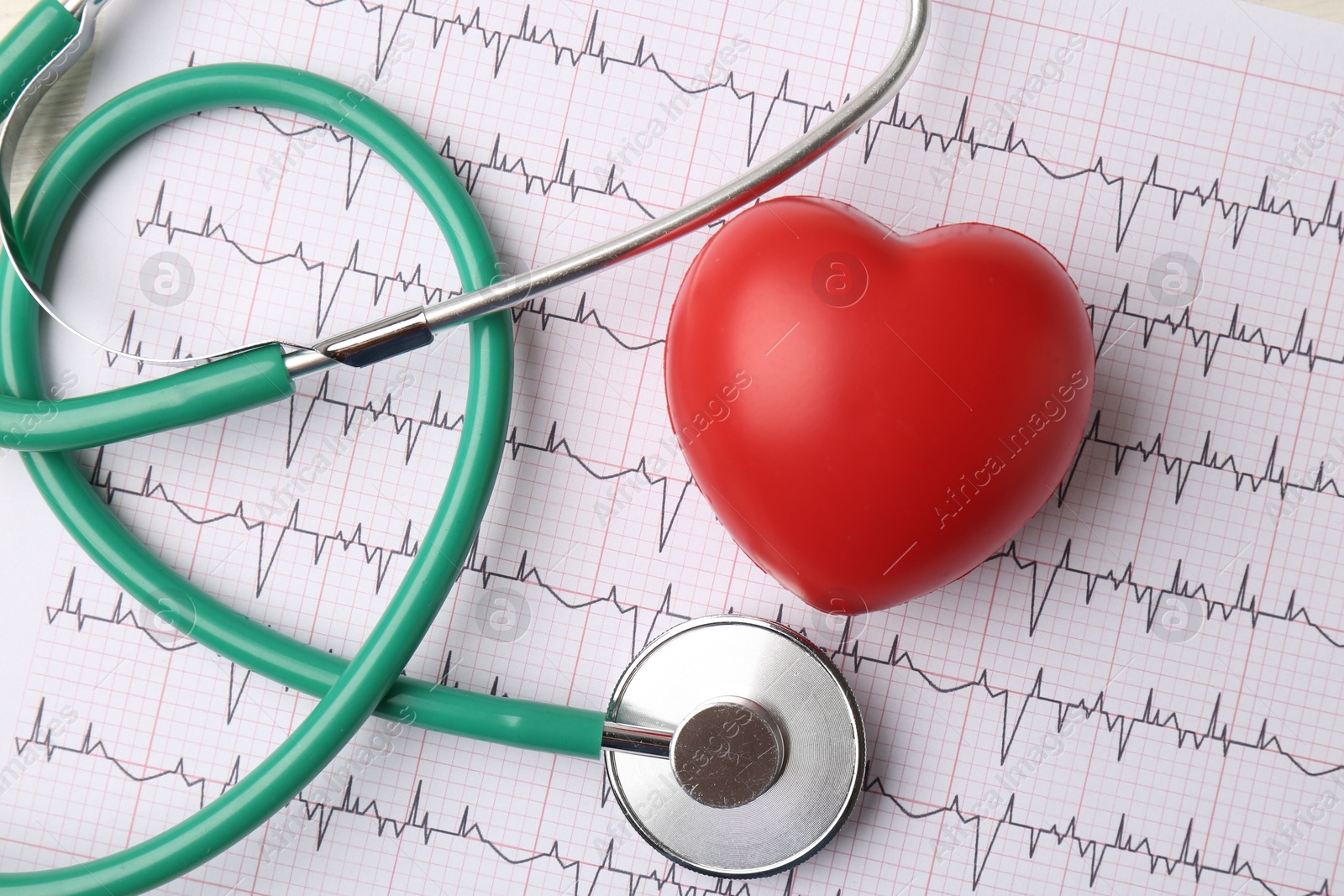 Photo of Cardiology. Stethoscope and red decorative heart on paper with cardiogram, flat lay