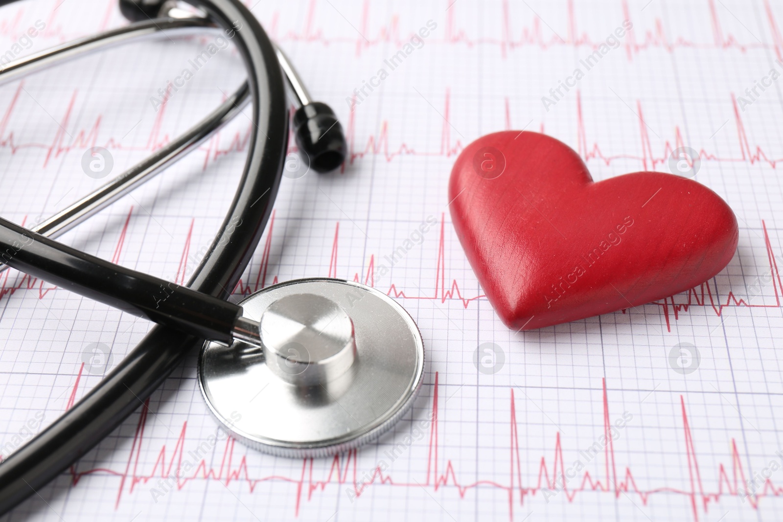 Photo of Cardiology. Stethoscope and red decorative heart on paper with cardiogram, closeup