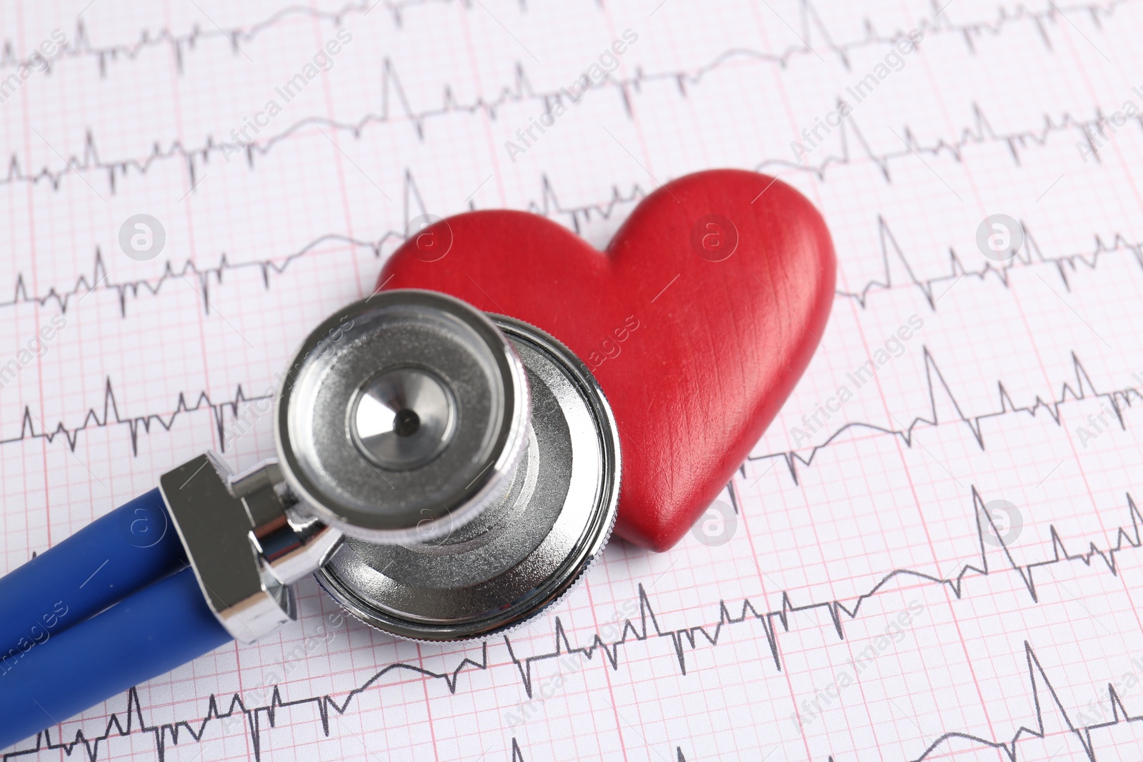 Photo of Cardiology. Stethoscope and red decorative heart on paper with cardiogram, closeup