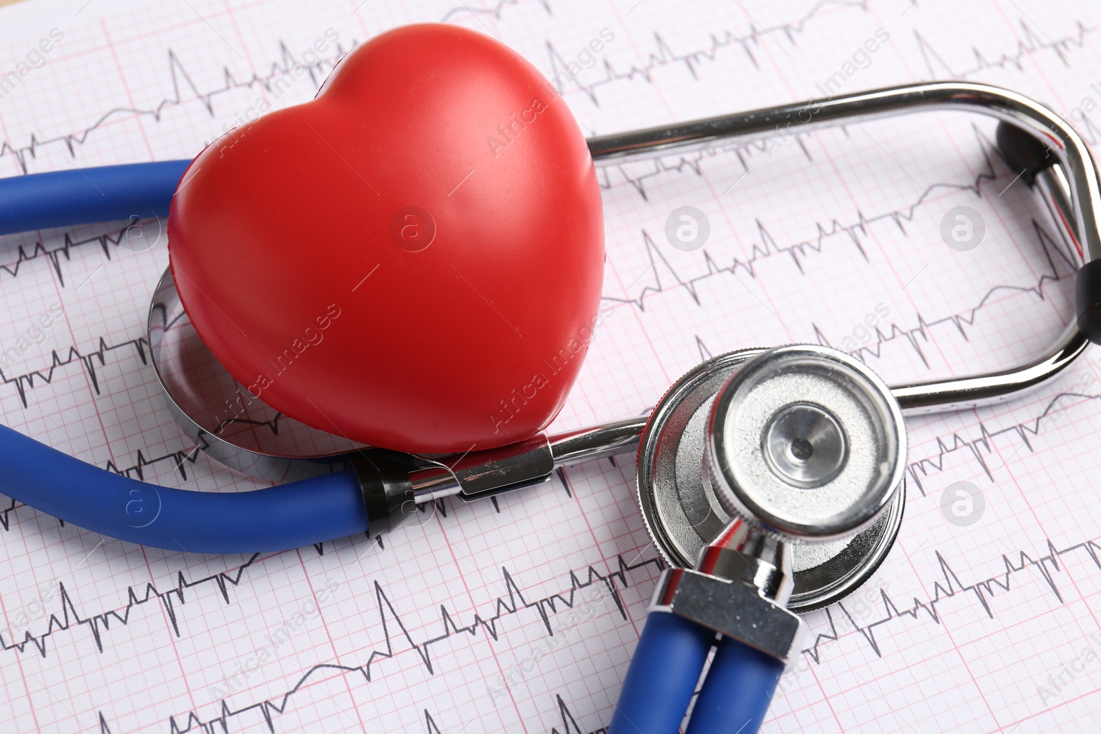 Photo of Cardiology. Stethoscope and red decorative heart on paper with cardiogram, closeup