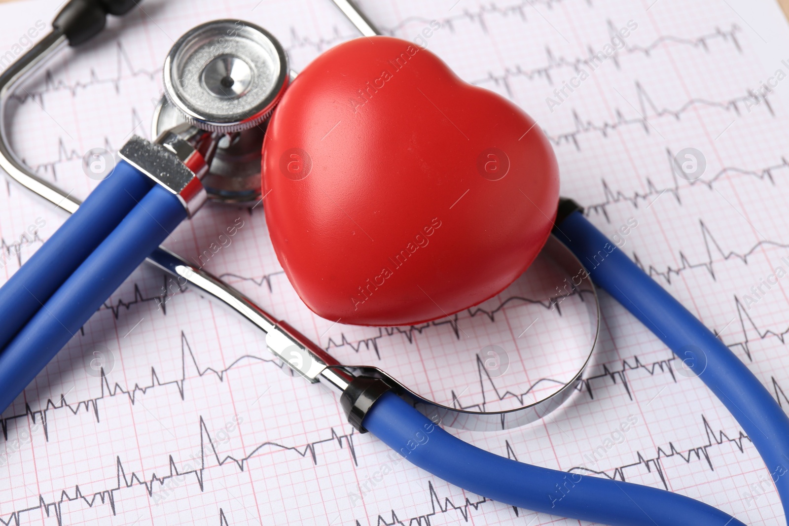 Photo of Cardiology. Stethoscope and red decorative heart on paper with cardiogram, closeup