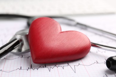 Photo of Cardiology. Stethoscope and red decorative heart on paper with cardiogram, closeup