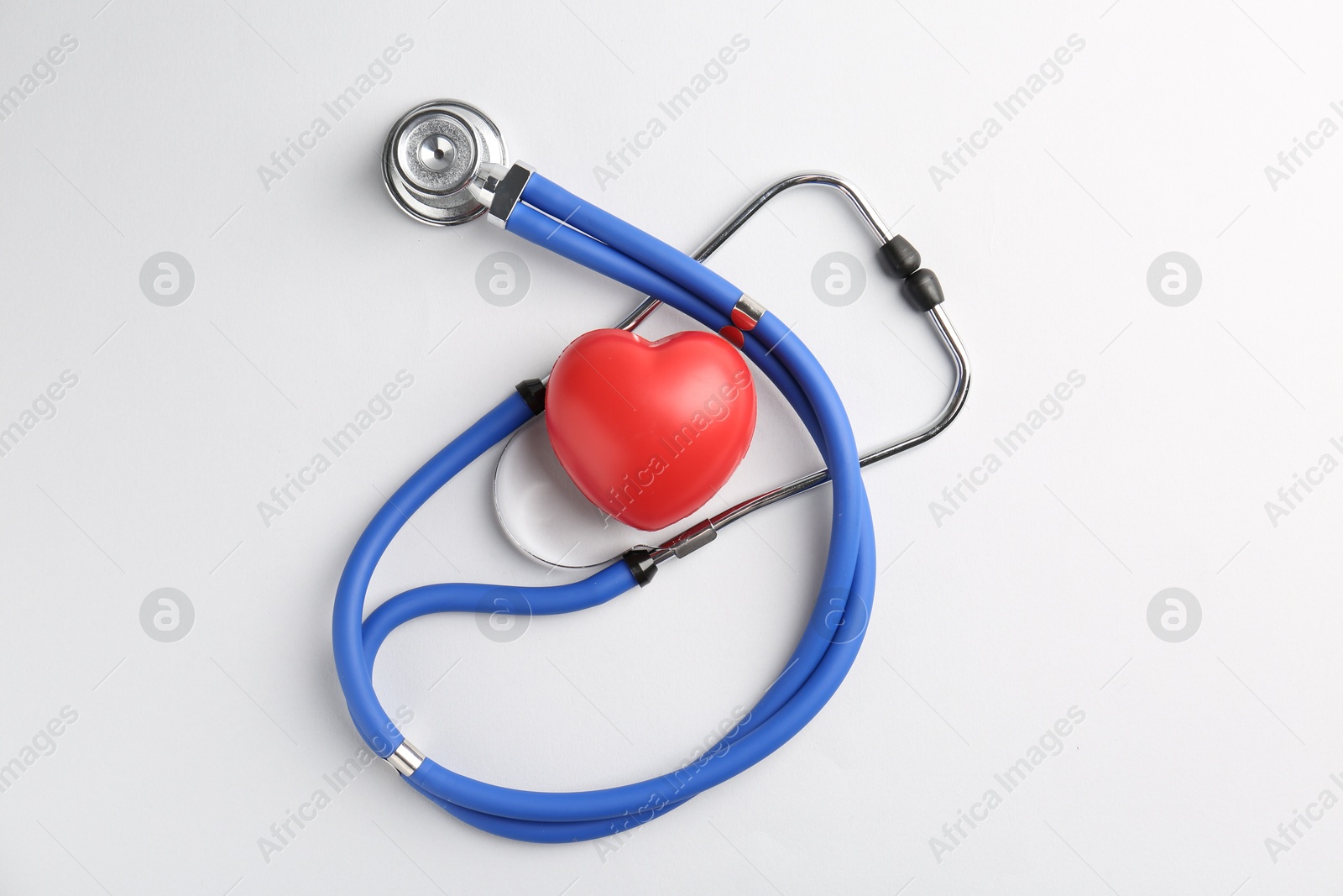 Photo of Cardiology. Stethoscope and red decorative heart on white background, flat lay