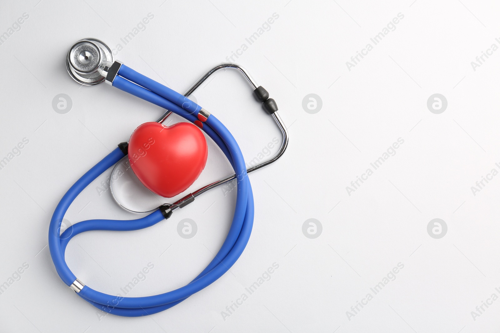 Photo of Cardiology. Stethoscope and red decorative heart on white background, flat lay. Space for text