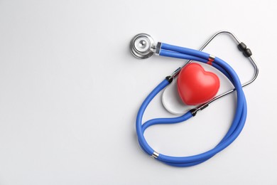 Photo of Cardiology. Stethoscope and red decorative heart on white background, flat lay. Space for text