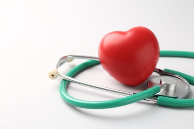 Photo of Cardiology. Stethoscope and red decorative heart on white background, closeup. Space for text