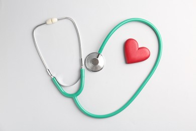 Photo of Cardiology. Stethoscope and red decorative heart on white background, flat lay