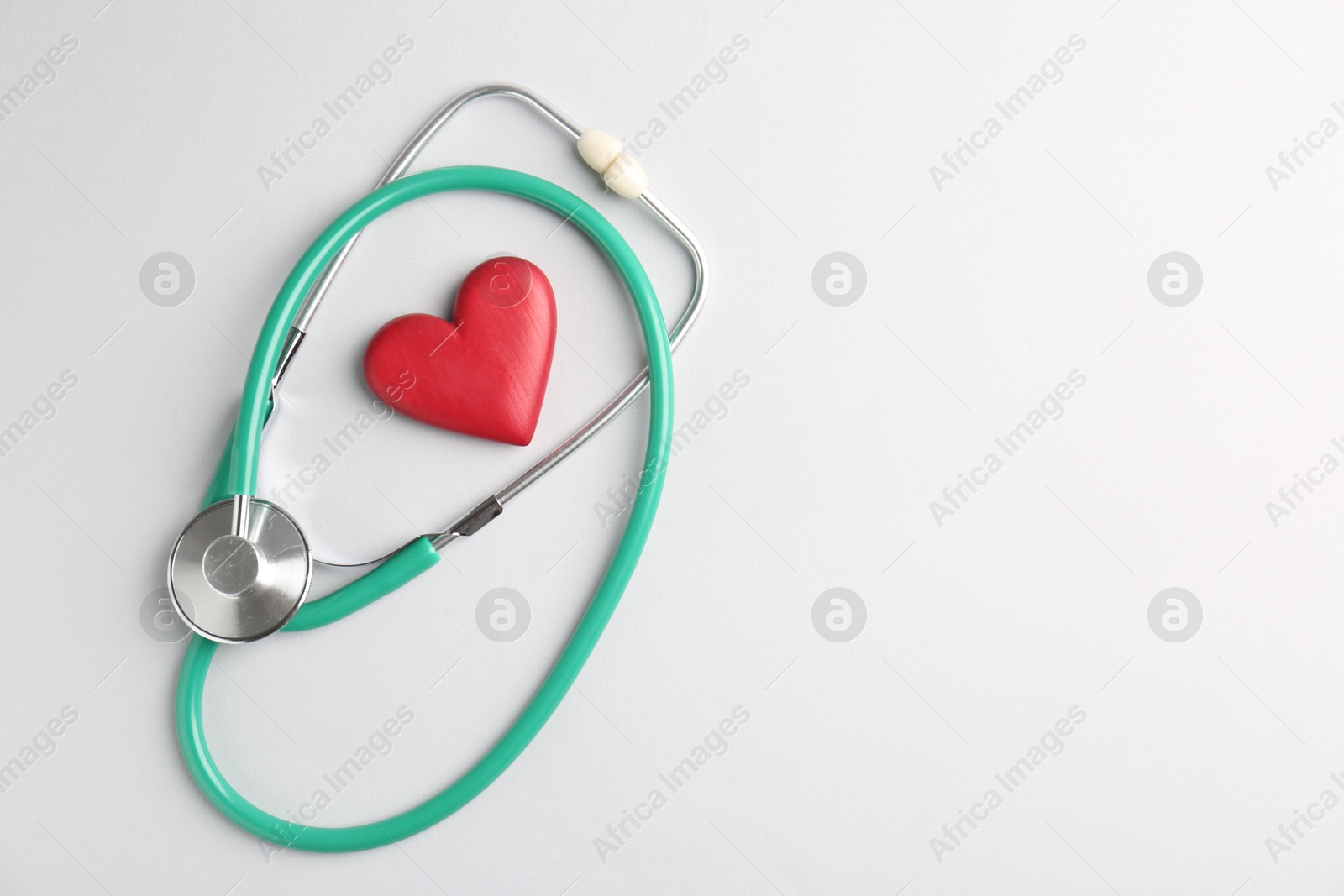 Photo of Cardiology. Stethoscope and red decorative heart on white background, flat lay. Space for text