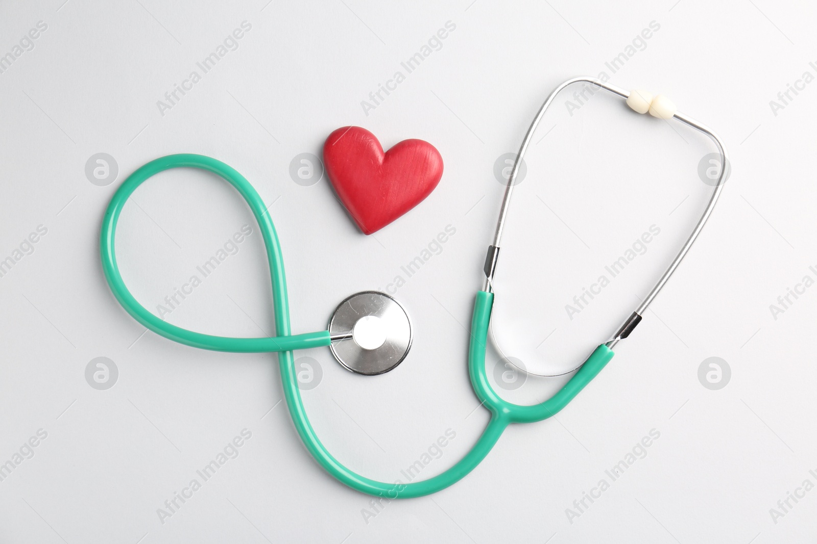 Photo of Cardiology. Stethoscope and red decorative heart on white background, flat lay