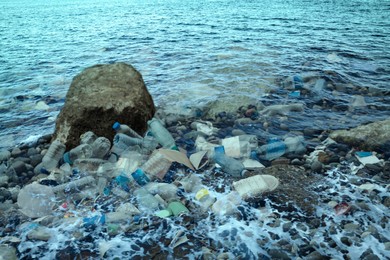 Image of Environmental pollution. Sea beach with plastic garbage