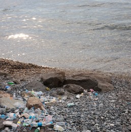 Image of Environmental pollution. Sea beach with plastic garbage