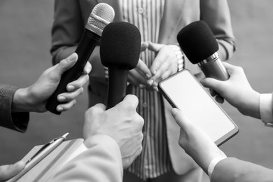 Journalists interviewing businesswoman, closeup. Toned in black-and-white