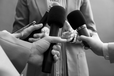 Image of Journalists interviewing businesswoman, closeup. Toned in black-and-white