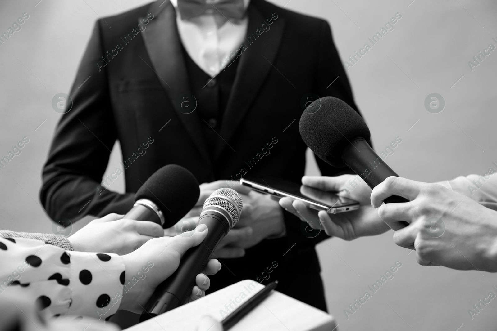 Image of Journalists interviewing celebrity, closeup. Toned in black-and-white