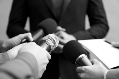 Image of Journalists interviewing businessman, closeup. Toned in black-and-white