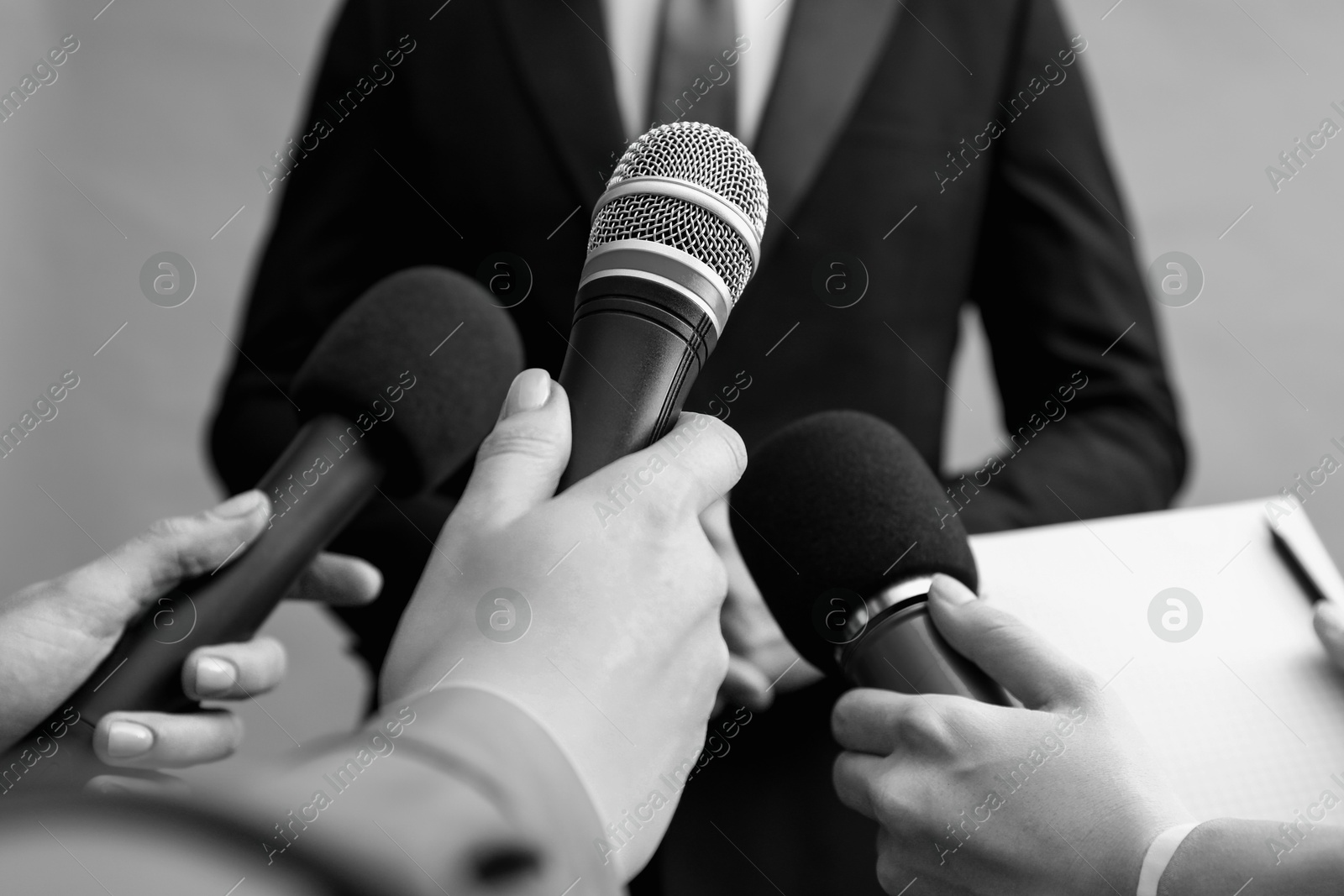 Image of Journalists interviewing businesswoman, closeup. Toned in black-and-white