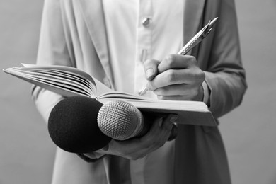 Image of Journalist with microphones taking notes, closeup. Toned in black-and-white