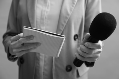 Image of Journalist with microphone and notebook, closeup. Toned in black-and-white