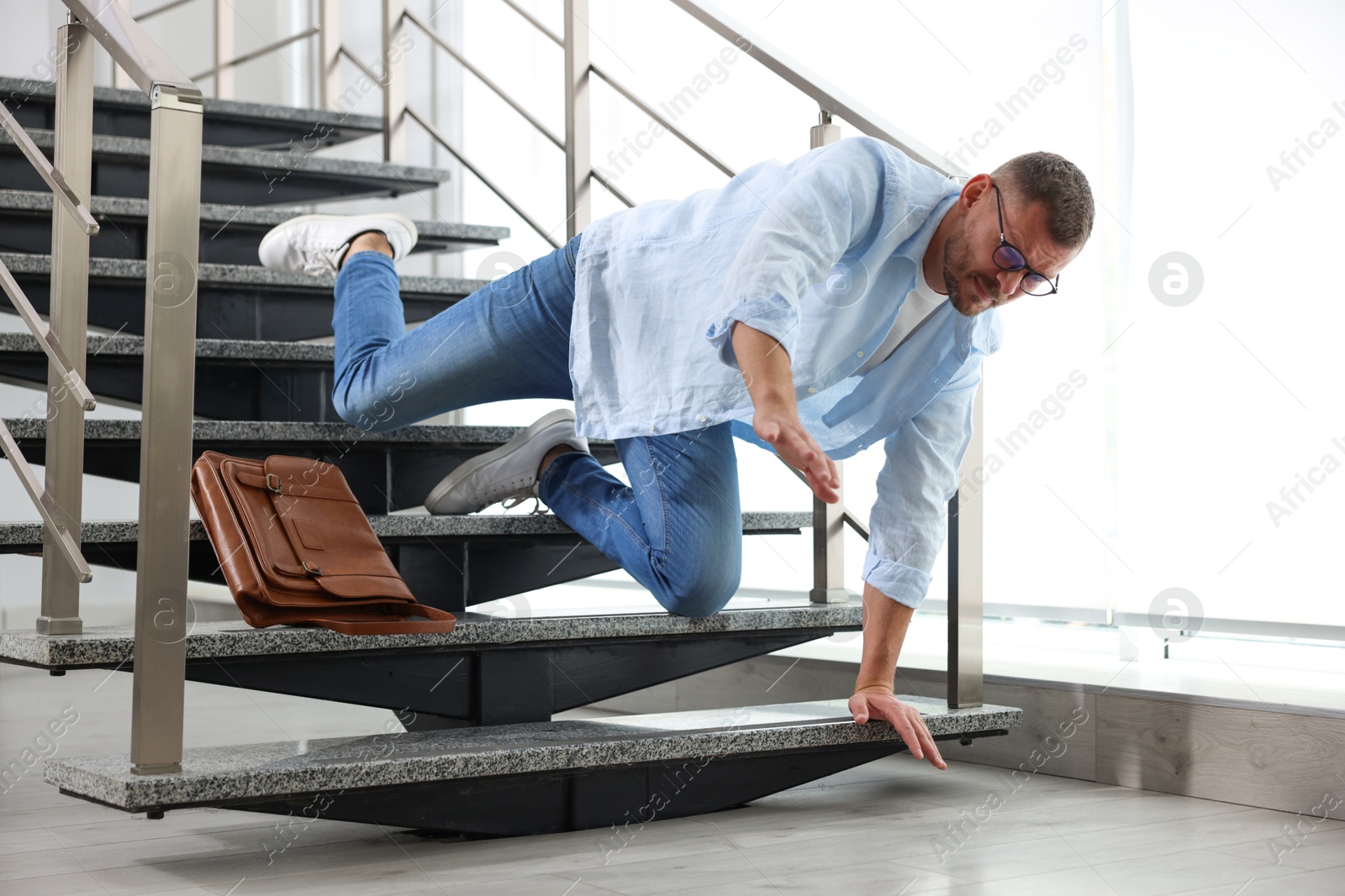 Photo of Man falling on stairs in building. Dangerous accident