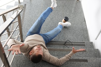 Photo of Injured man on stairs in building after fall, above view. Dangerous accident