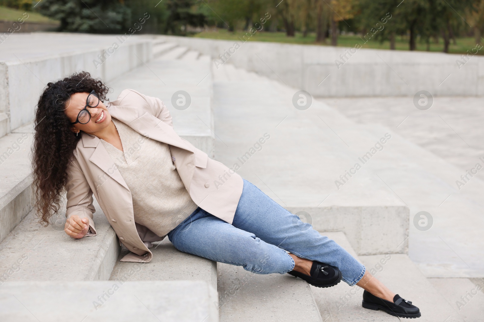 Photo of Injured woman on stairs outdoors after fall. Dangerous accident