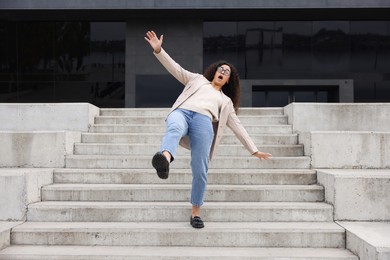 Photo of Woman falling on stairs outdoors. Dangerous accident