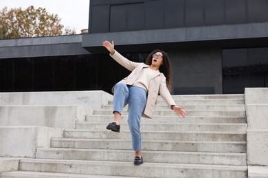 Photo of Woman falling on stairs outdoors. Dangerous accident