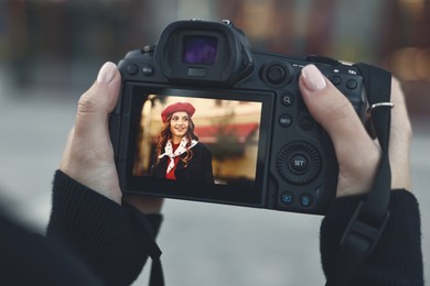 Photo of Professional photographer with digital camera outdoors, closeup