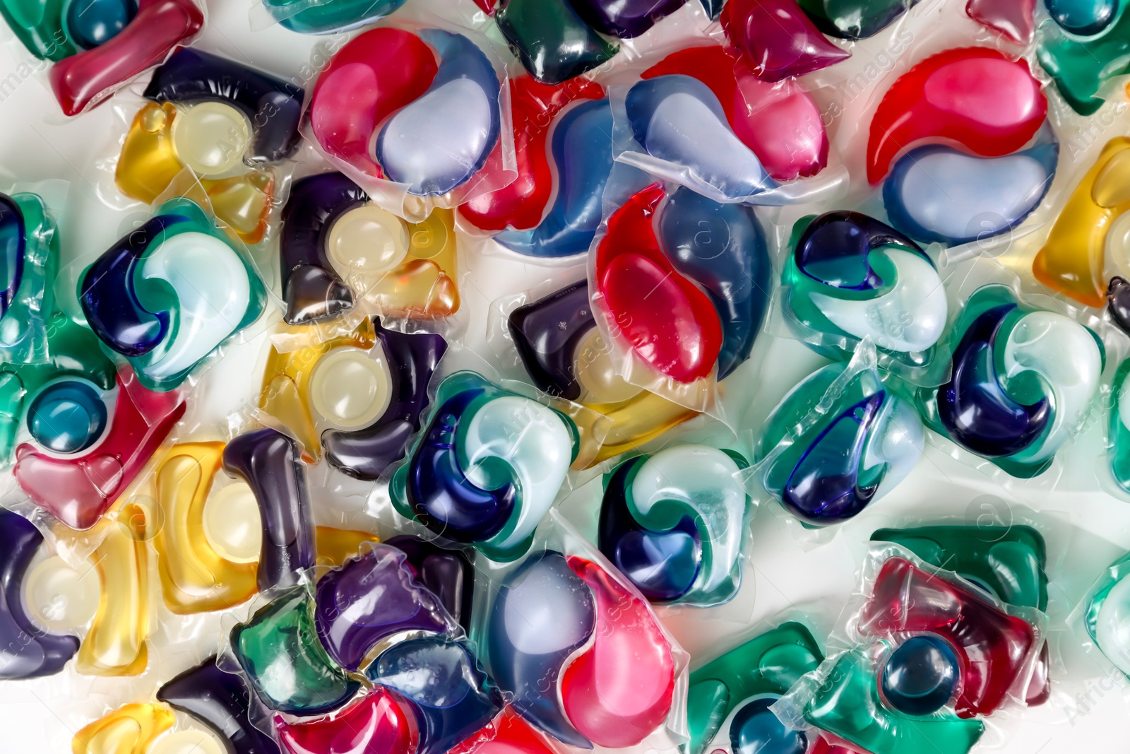 Photo of Different laundry detergent capsules on white background, top view