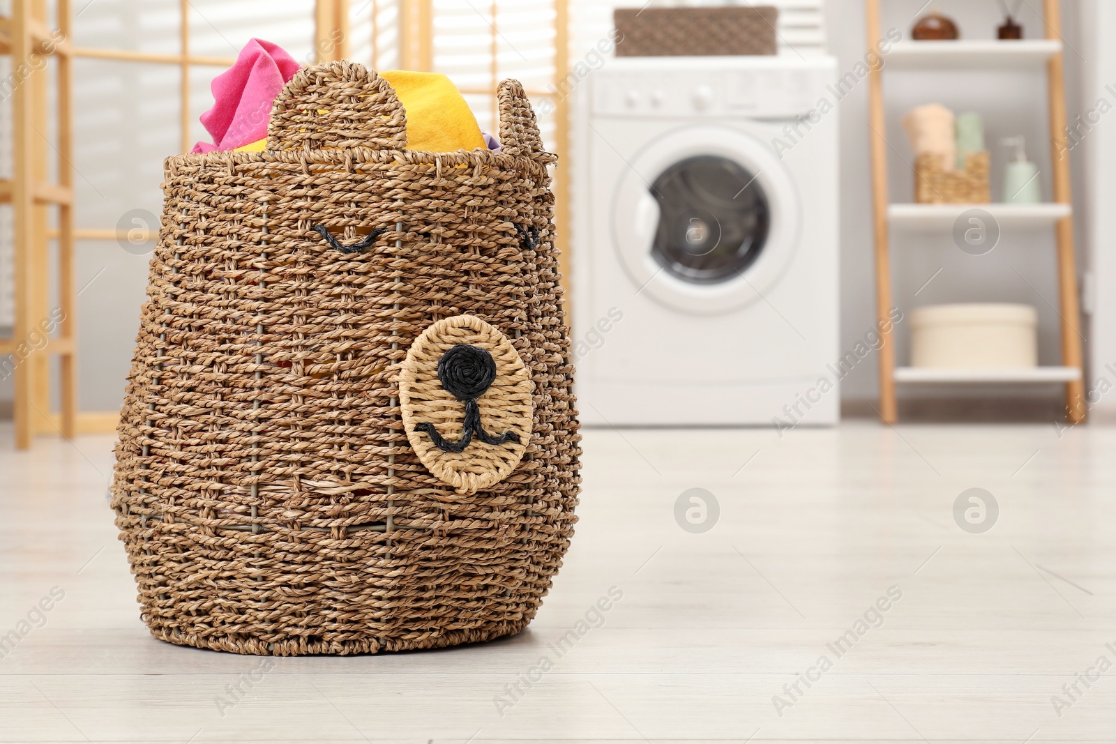 Photo of Wicker basket full of laundry in bathroom