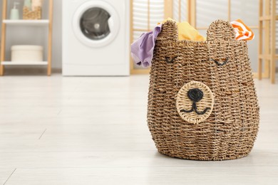 Photo of Wicker basket full of laundry in bathroom