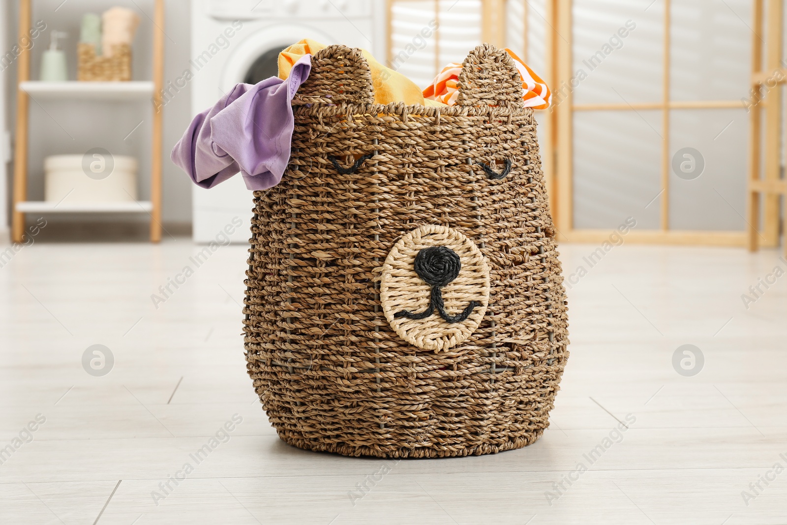 Photo of Wicker basket full of laundry in bathroom