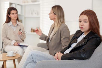 Photo of Difficult teenager. Mother and daughter having consultation with psychologist in office, selective focus