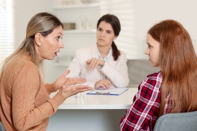 Photo of Difficult teenager. Mother and daughter having consultation with psychologist in office, selective focus