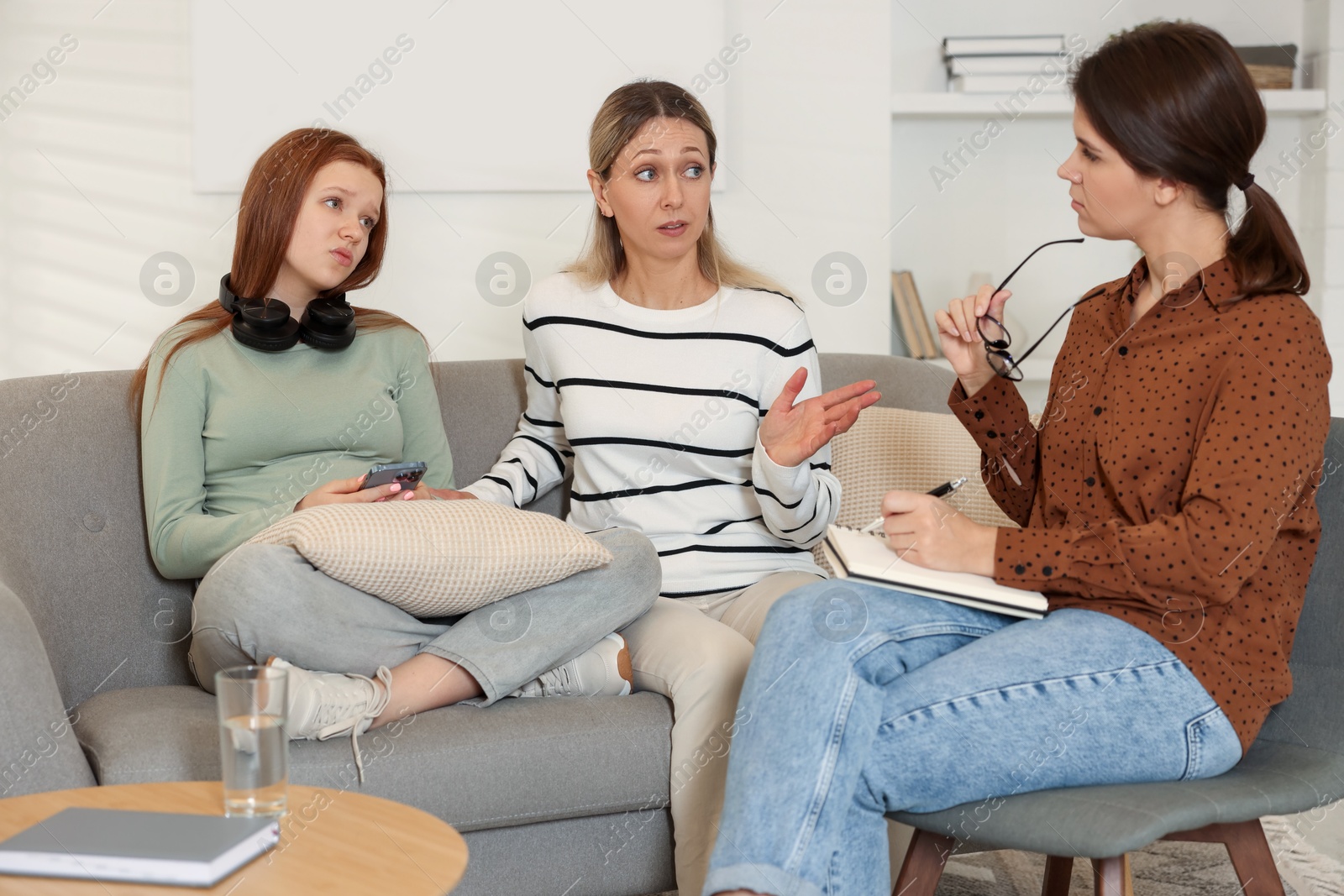 Photo of Difficult teenager. Mother and daughter having consultation with psychologist in office