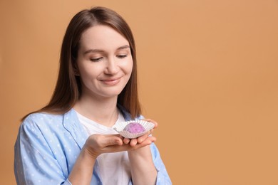 Photo of Woman with tasty mochi on light brown background. Space for text