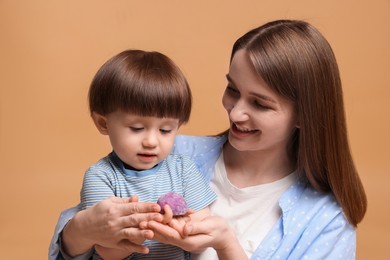 Photo of Mother and baby eating tasty mochi on brown background