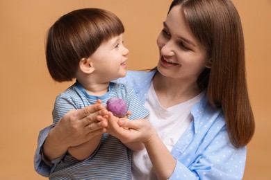 Photo of Mother and baby eating tasty mochi on brown background