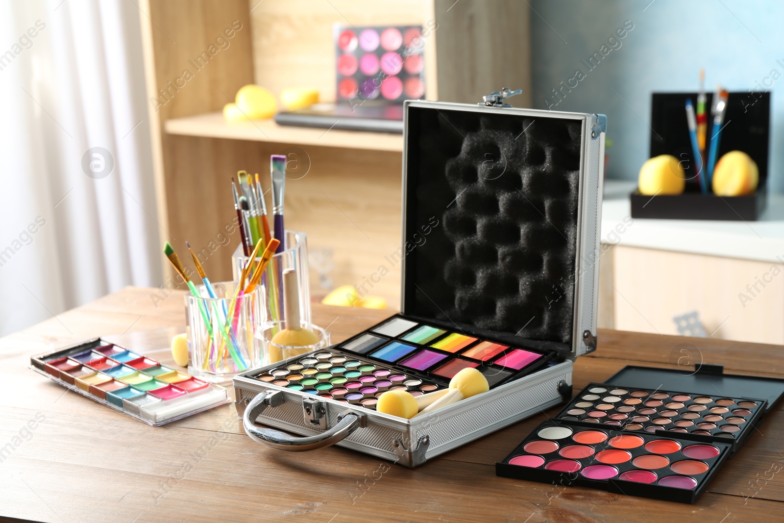 Photo of Face paints and tools on wooden table indoors