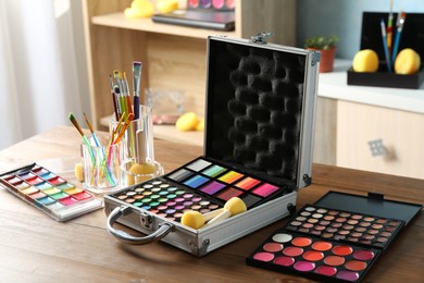 Photo of Face paints and tools on wooden table indoors