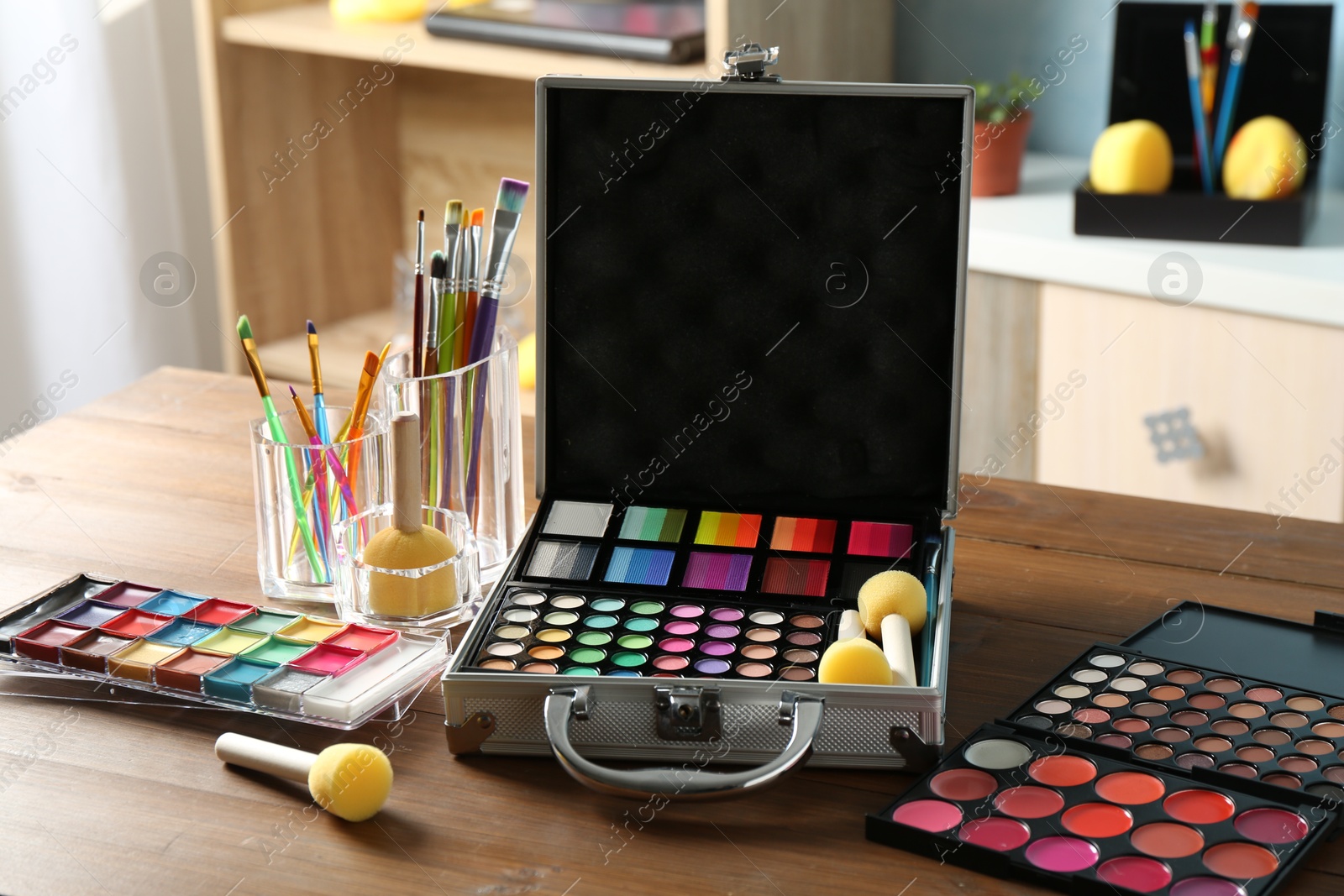 Photo of Face paints and tools on wooden table indoors