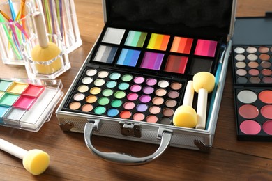 Photo of Face paints and tools on wooden table, closeup