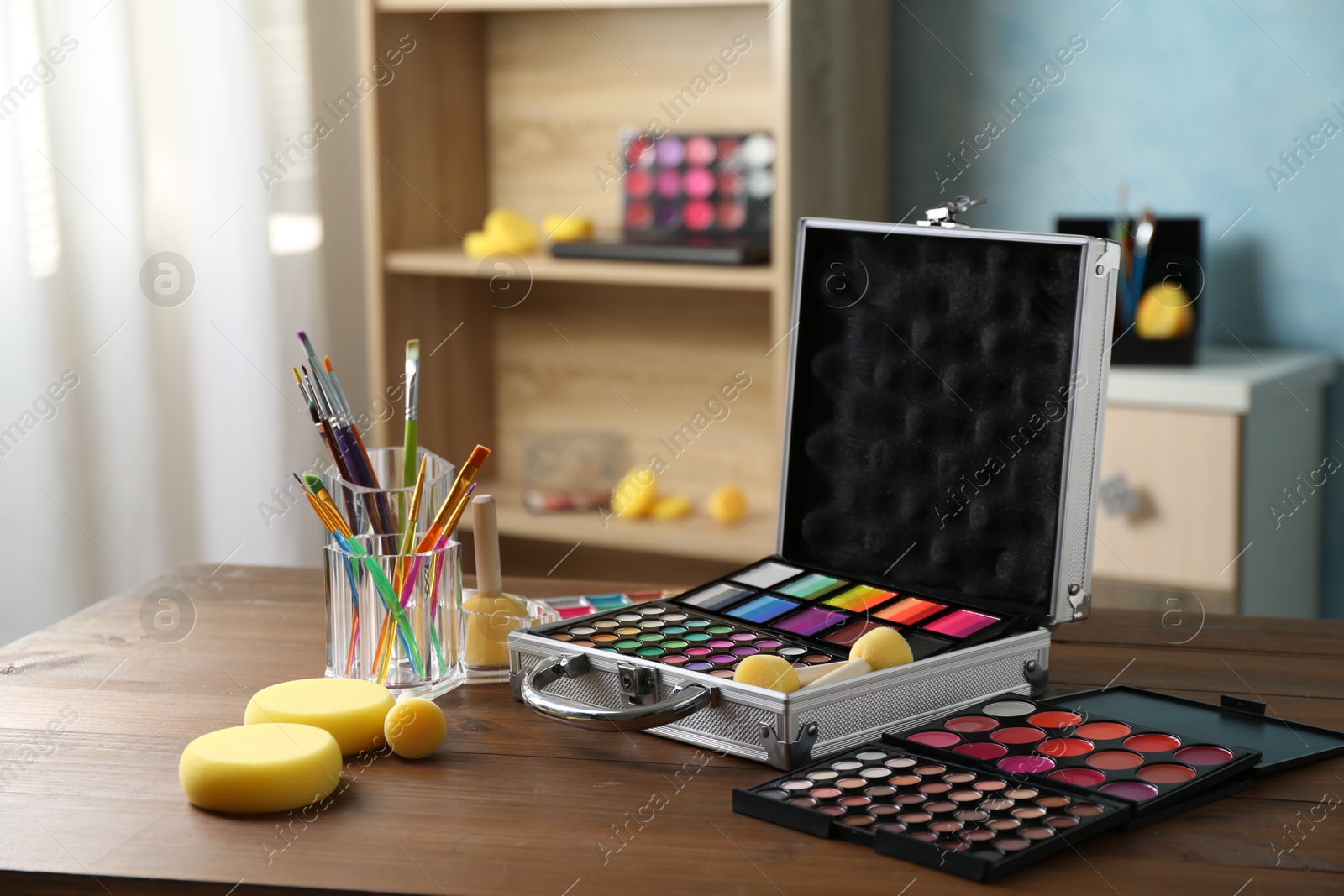 Photo of Face paints and tools on wooden table indoors. Space for text