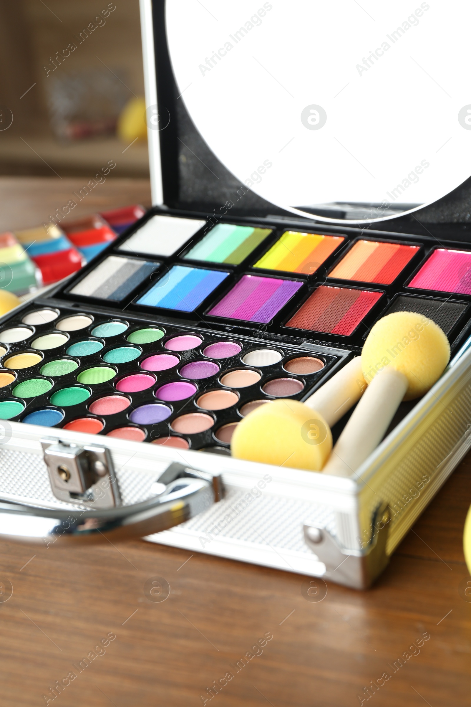 Photo of Face paints and tools on wooden background, closeup