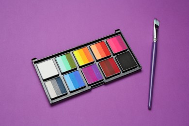 Photo of Face paints and brush on purple background